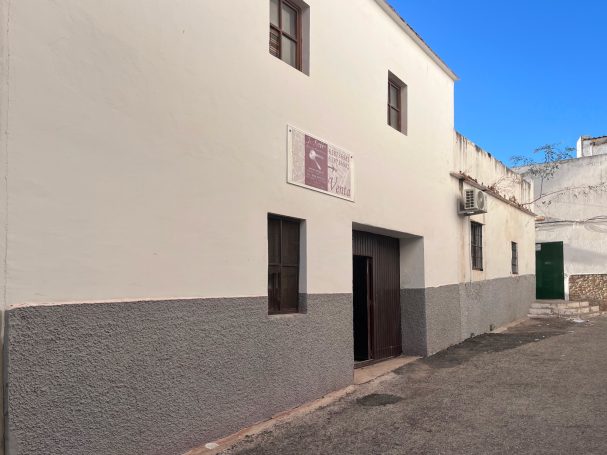 Fachada trasera de la propiedad en pleno centro de Conil. Se ve la puerta de garaje y las ventanas que tiene la fachada.